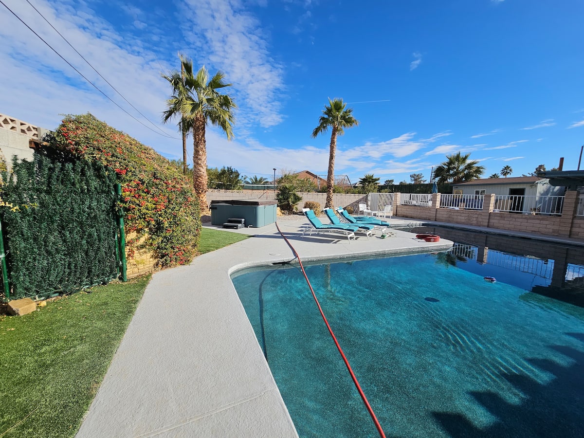 Long pool lined with palm trees and lounge chairs at Spencer Dream Estate
