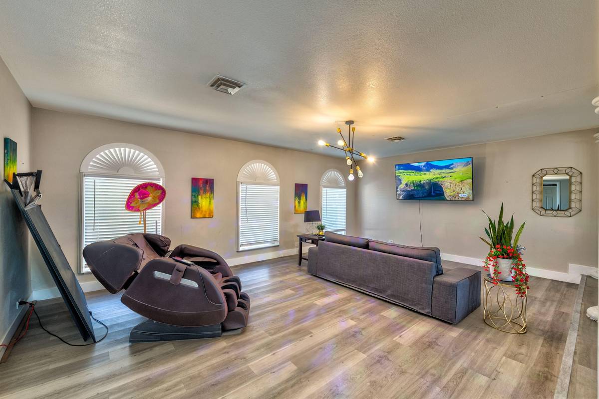 Second living room with massage chair, sofa and wall-mounted television at Pama Lane