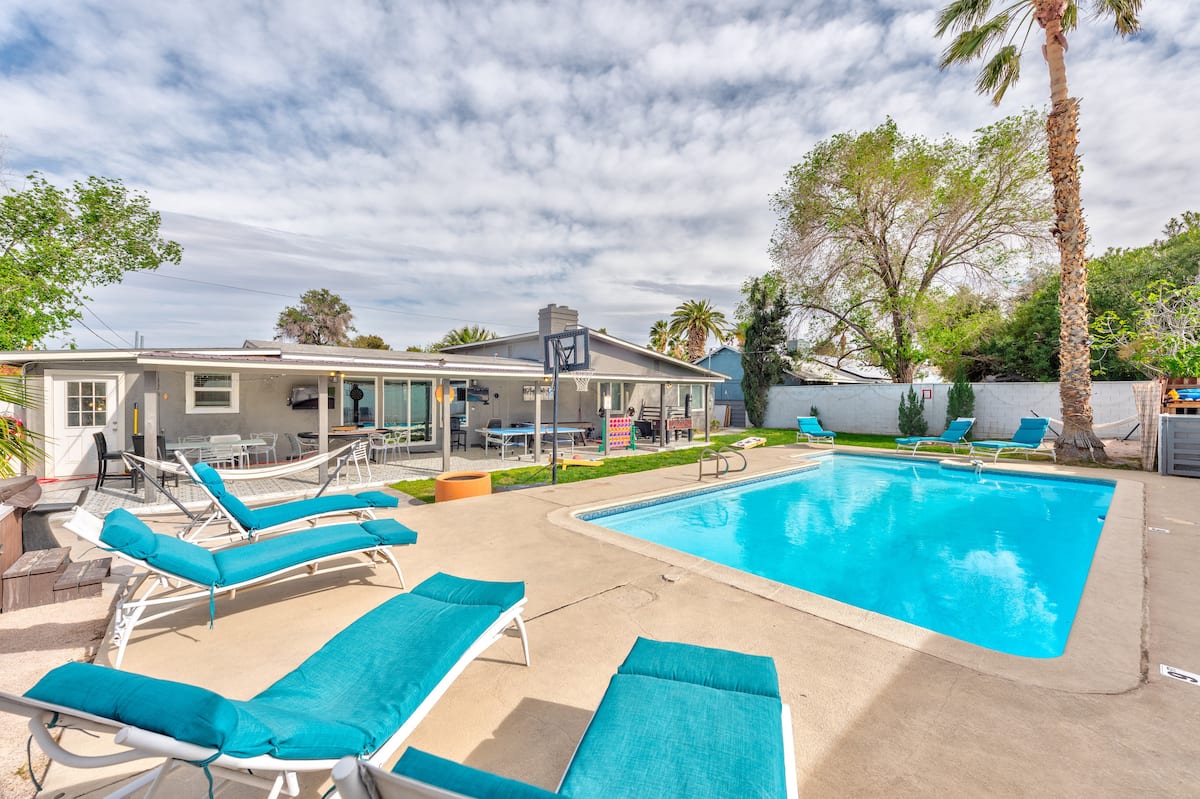 Private backyard pool with lounge chairs at Cashman Dream House in Las Vegas