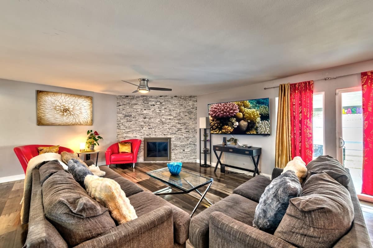 Living room with sectional seating and a stone fireplace wall at Cashman Dream House