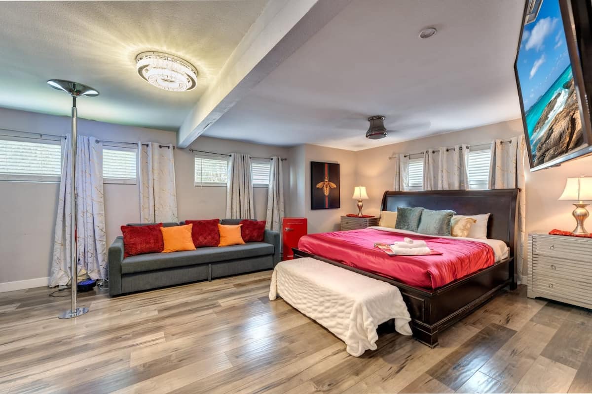 Bedroom with a king bed, sofa and bright windows at Cashman Dream House