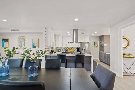Kitchen island with stainless appliances and an adjoining dining table at Pama Lane