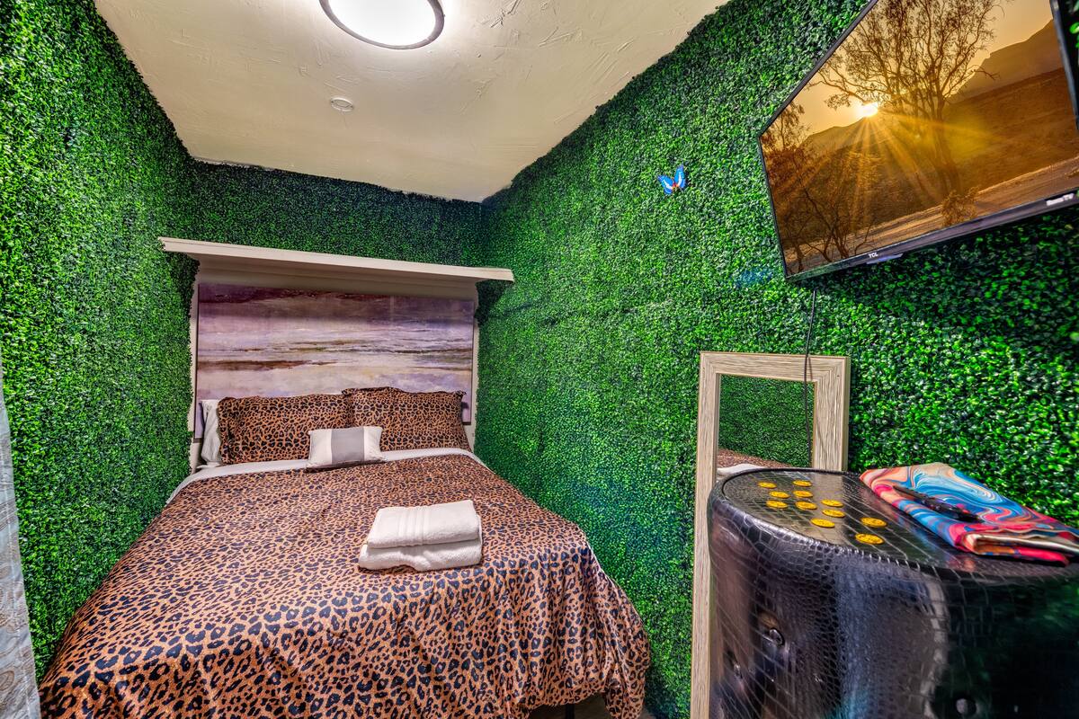 Bedroom with green patterned wall covering and a queen bed at Spencer Dream Estate