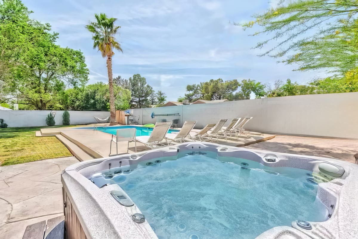Five-person hot tub beside the pool at Cashman Dream House
