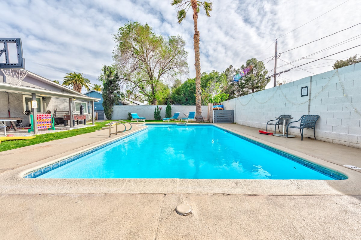 Fenced backyard with pool and patio seating at Cashman Dream House in Las Vegas