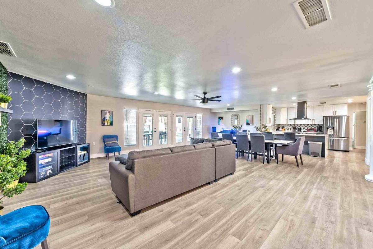 Open great room with sectional sofa, television wall and dining area beyond at Pama Lane