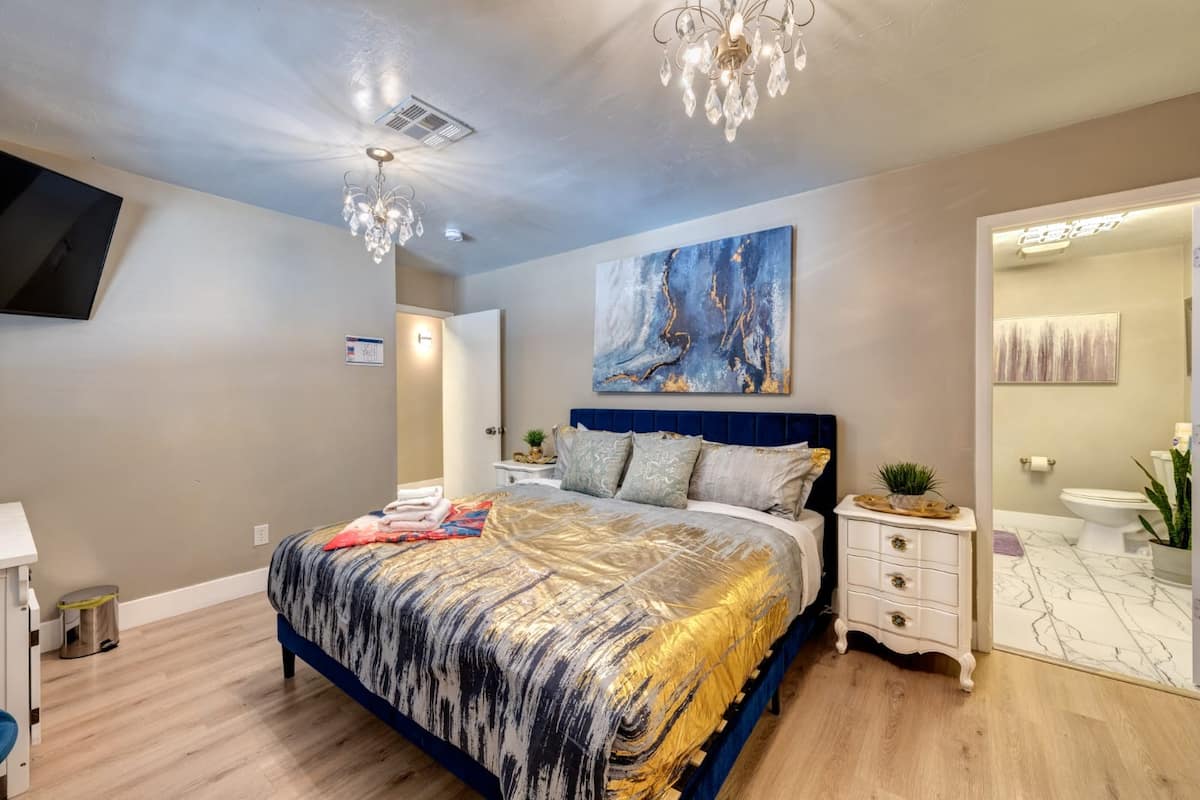 Bedroom with a chandelier and adjoining bathroom at Spencer Dream Estate
